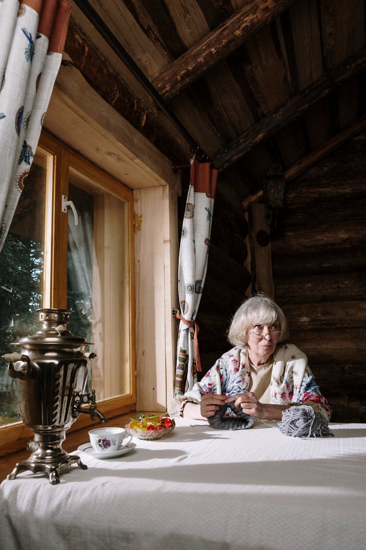 Grandmother Knitting At A Table