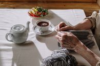 Person Holding White Ceramic Teacup on Saucer