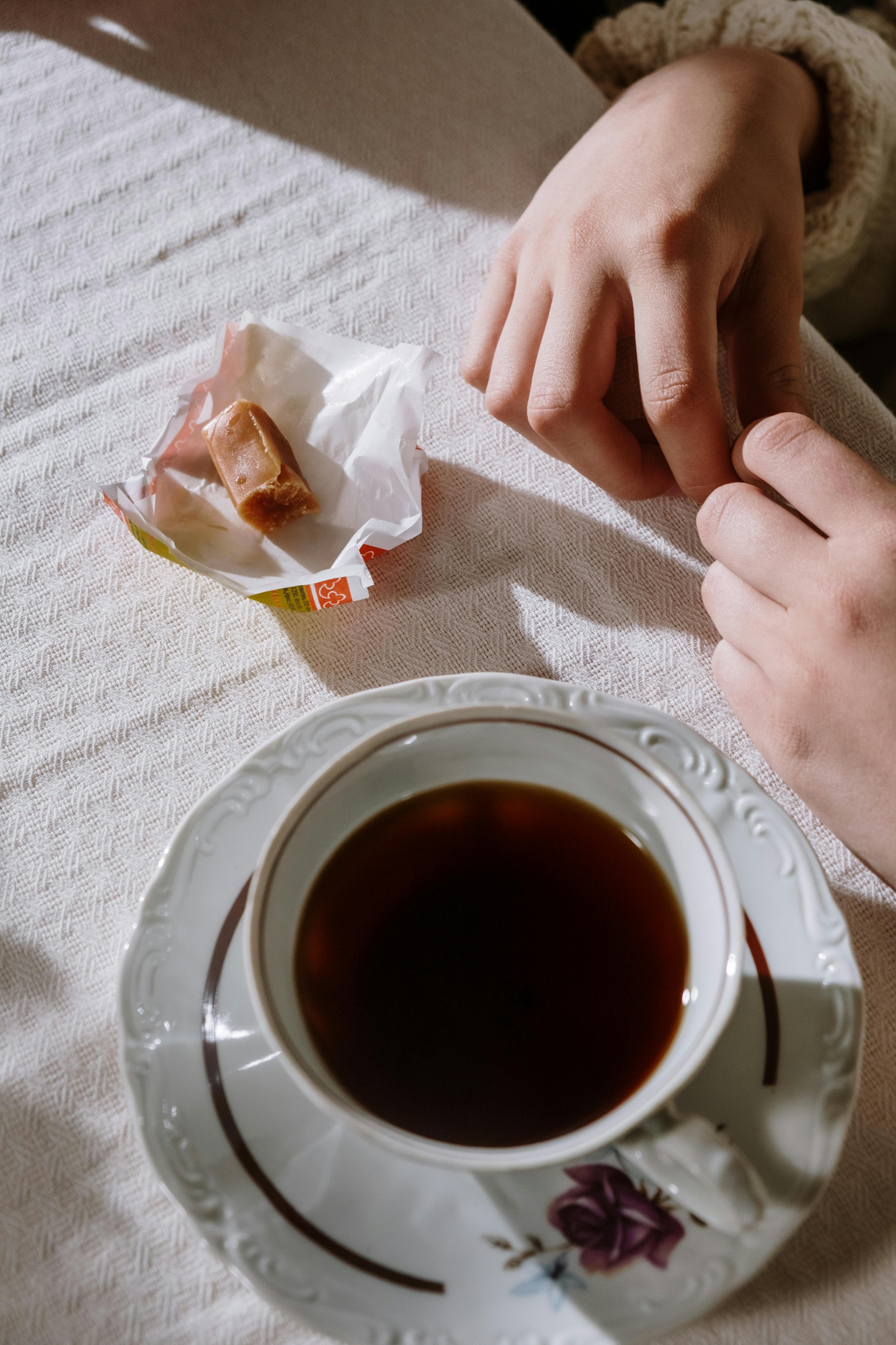 a candy beside a cup of tea