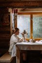 Woman in White Long Sleeve Shirt Sitting on Chair in Front of Table