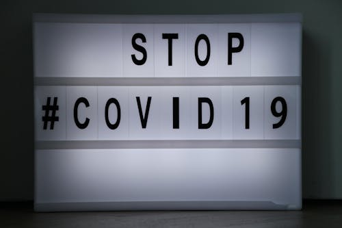 Grayscale Photo of Stop #Covid19 Signage