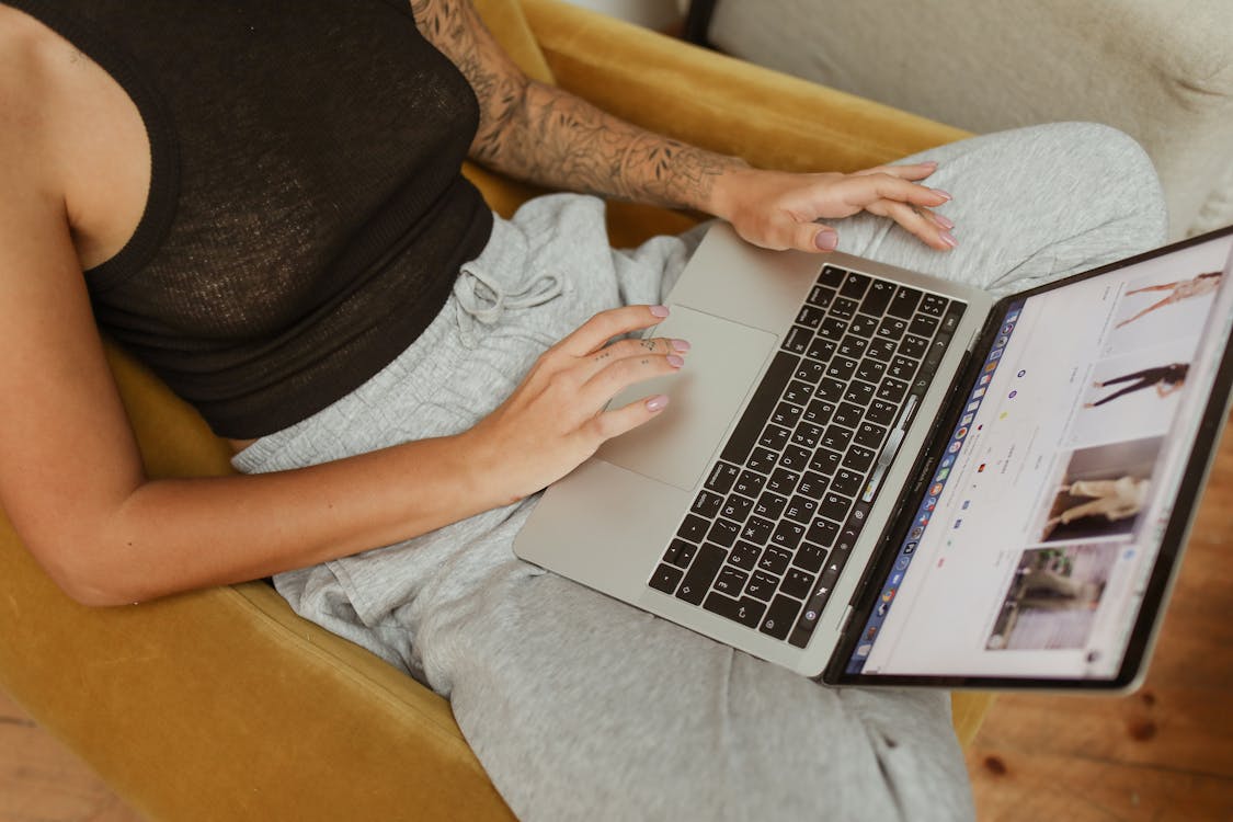 Free A Person in Black Tank Top Using Laptop Stock Photo