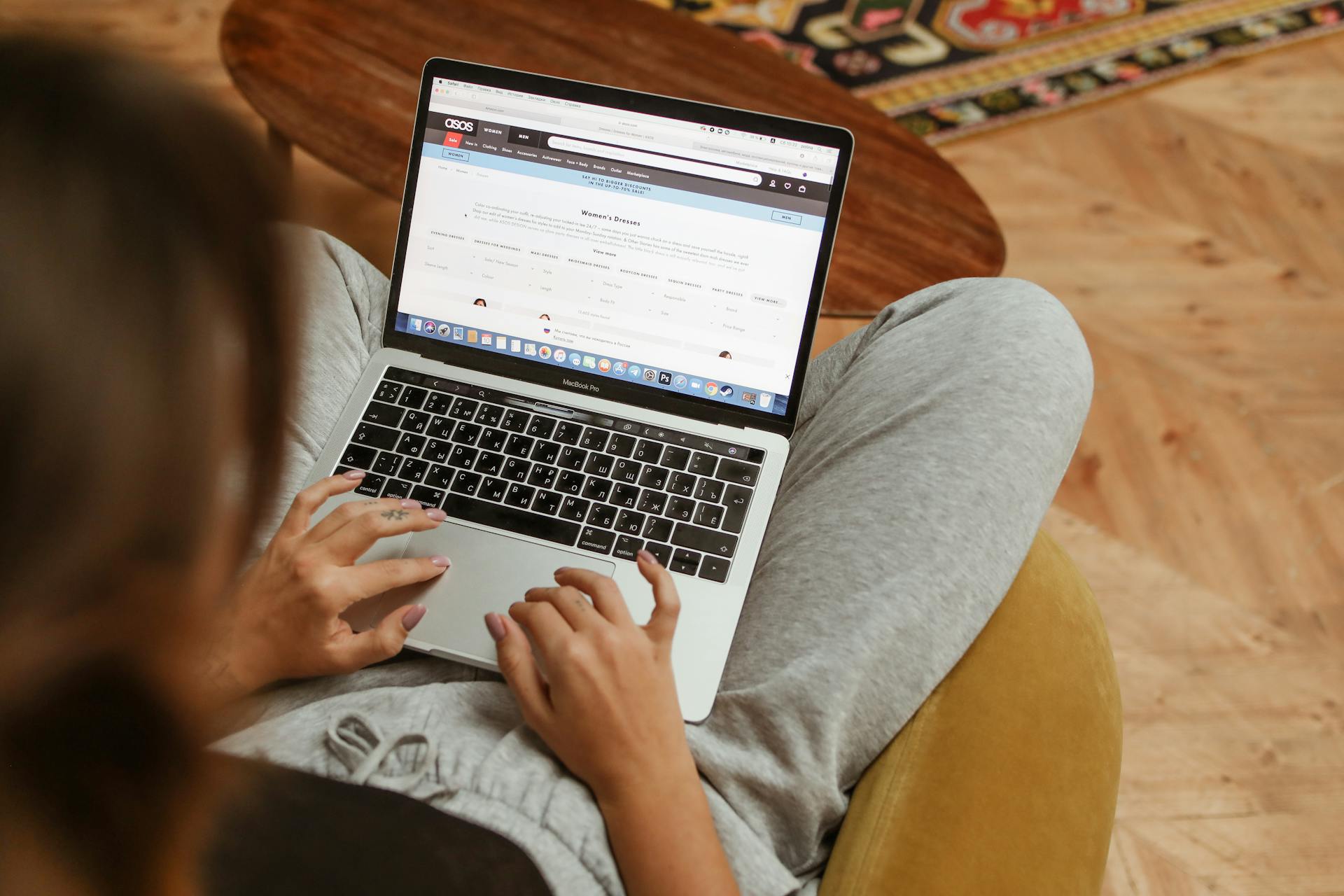 A woman relaxes with her laptop browsing online shopping websites from her cozy home.