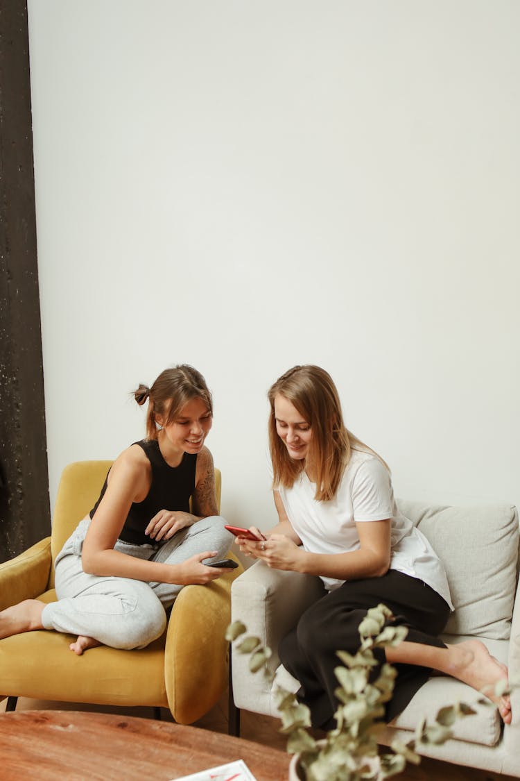 Friends Holding And Looking At Their Smartphones