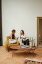 Woman in Black Tank Top Sitting on Brown Sofa Chair