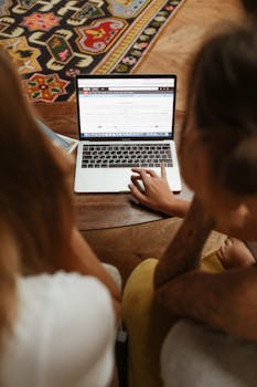 Two individuals browsing an online store together on a laptop, engaged in digital shopping.