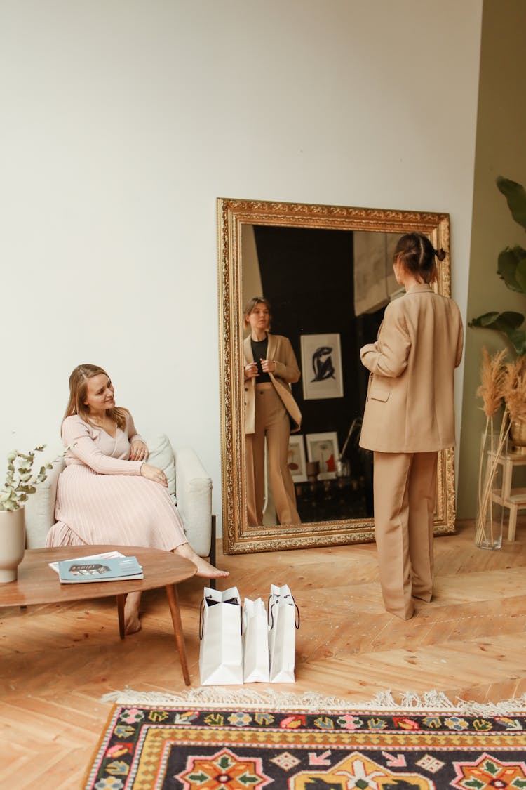 Woman In Brown Suit Standing In Front Of Mirror