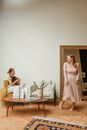 Barefooted Woman Trying On Beige Plitted Dress