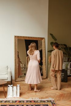 两个女人在一家精品店的大镜子前试穿时尚服装