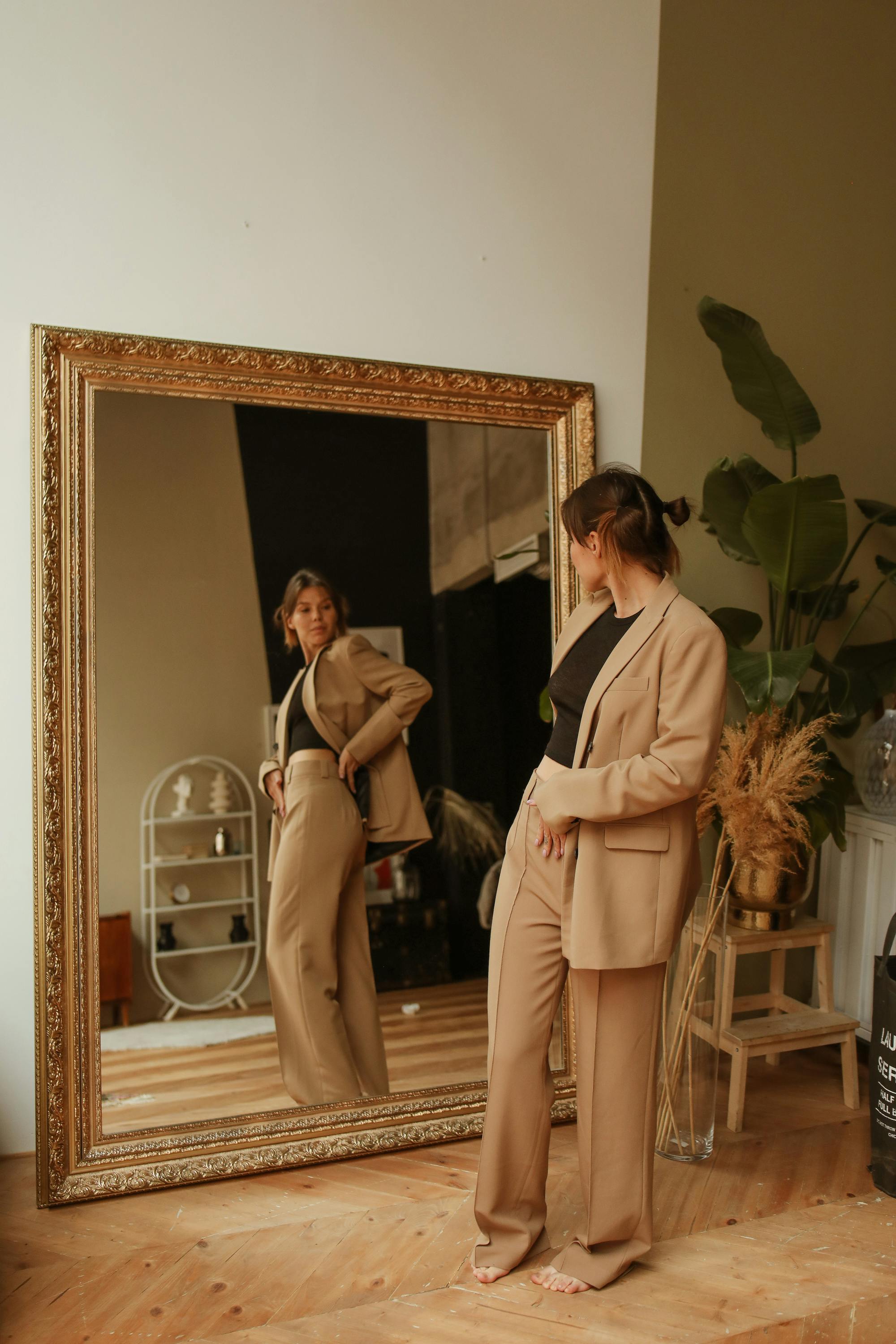 woman fitting a brown coat in front of a mirror