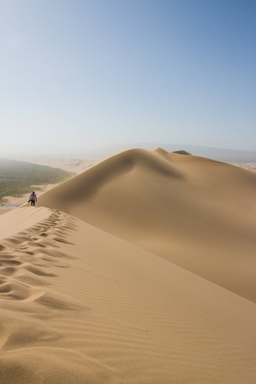 Person Walking Dunes in Desert