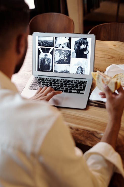 Kahverengi Ahşap Masada Macbook Pro Kullanan Kişi