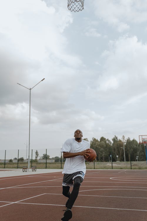 Man in White Shirt Playing Basketball