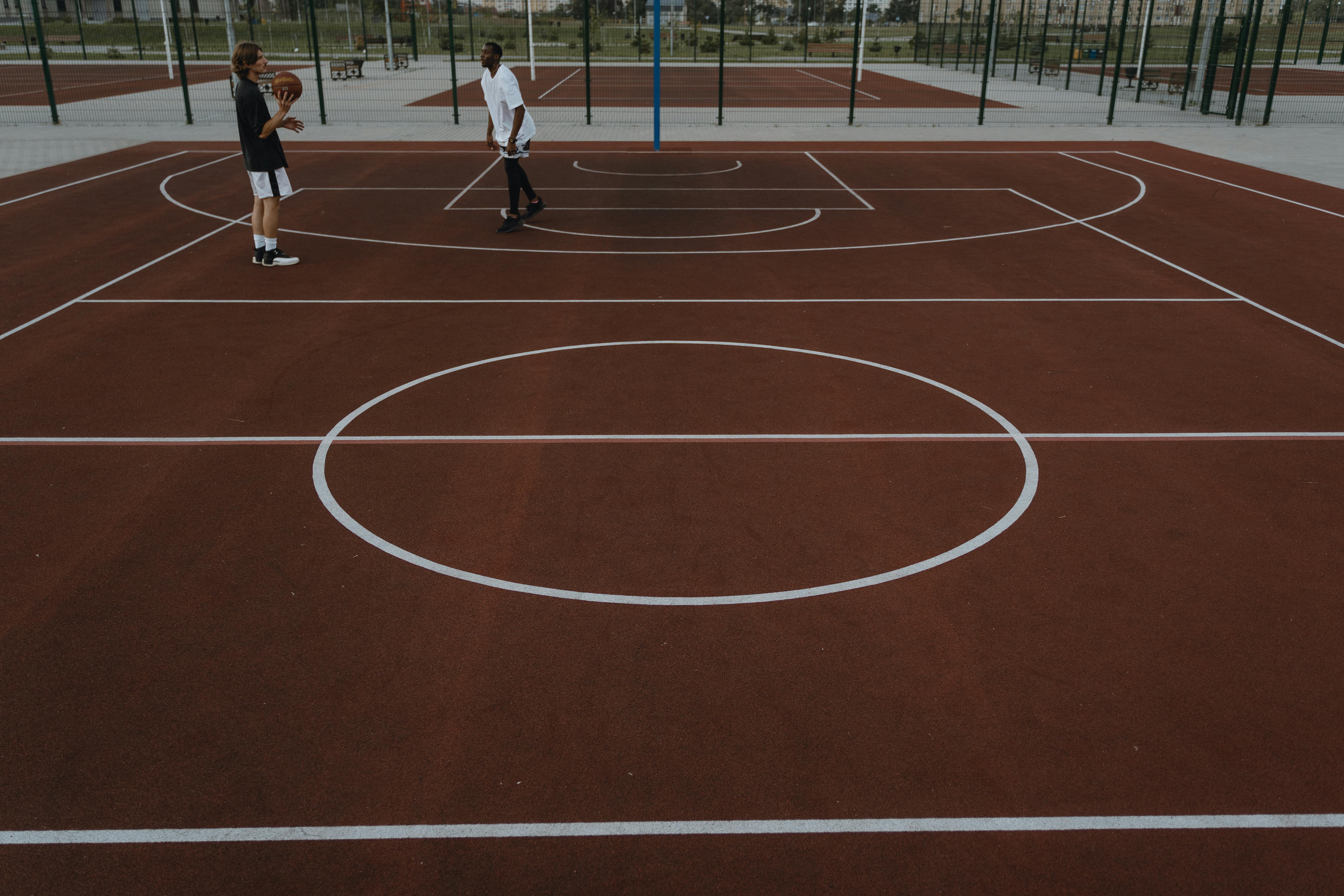 two people playing basketball on basketball court