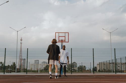 Two People Playing Basketball on Basketball Court