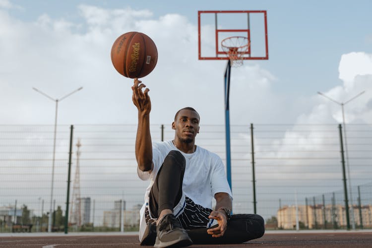 A Man Balancing A Ball On His Finger