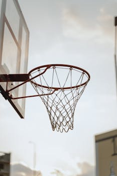 A basketball hoop captured outdoors with the sky in the background, ideal for sports-themed concepts.