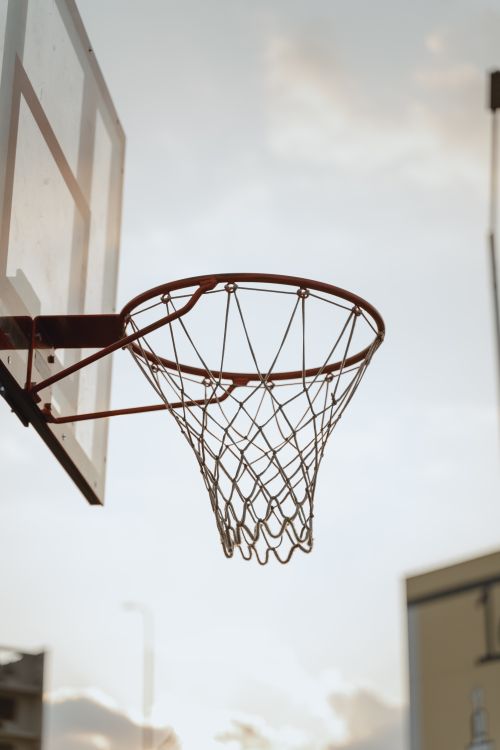 Free A basketball hoop captured outdoors with the sky in the background, ideal for sports-themed concepts. Stock Photo