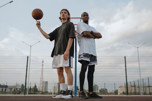 Low Angle Shot of Two Men Standing on Basketball Court