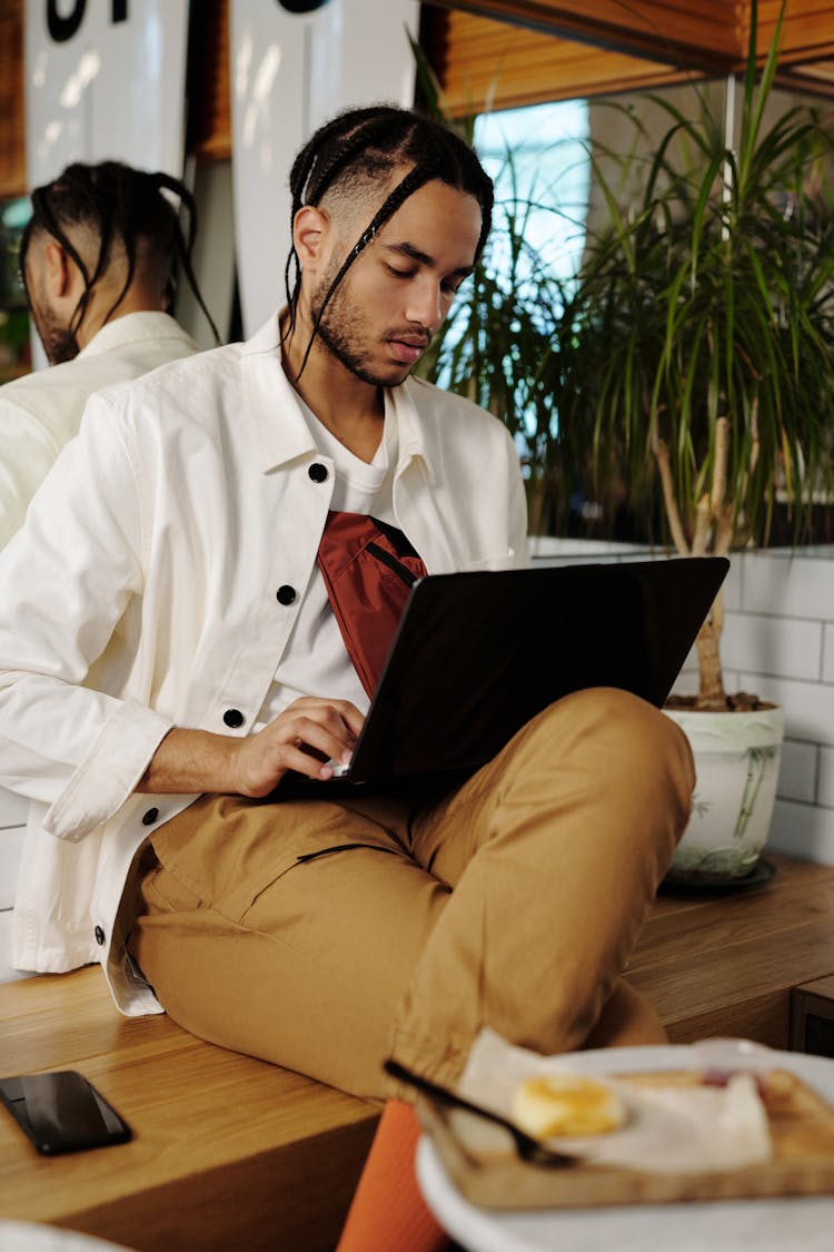 Man Sitting On Brown Wooden Bench Using Black Laptop