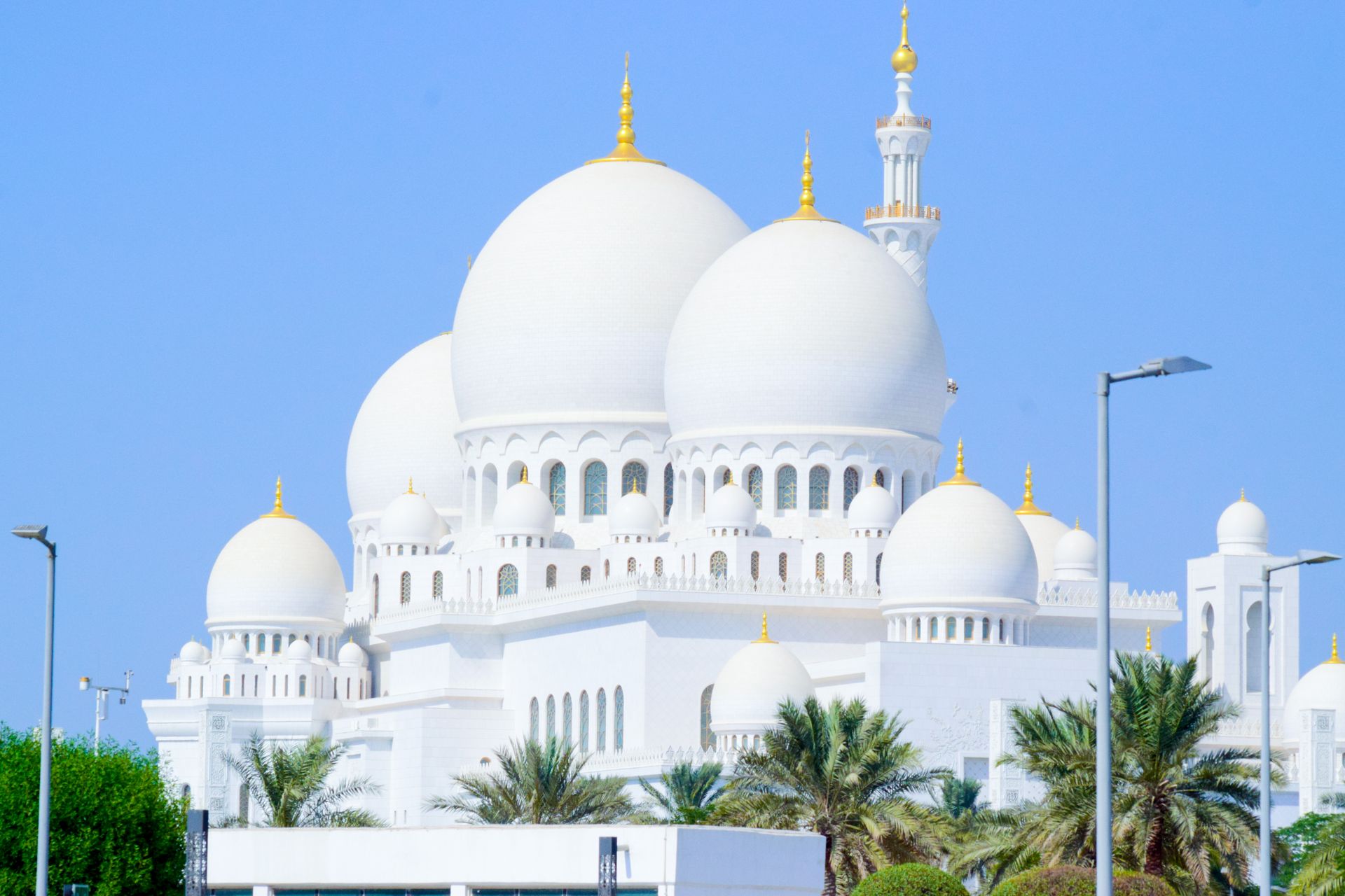 Beautiful shot of the iconic Sheikh Zayed Grand Mosque with clear blue skies, highlighting its archi