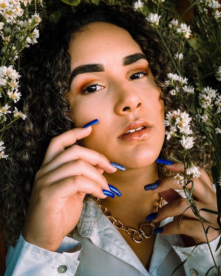 Photoshoot Of Woman With White Flowers And Blue Nail Polish