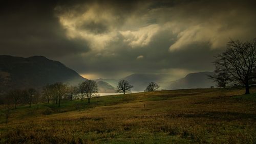 Free A moody landscape showcasing rolling hills, distant mountains, and an overcast sky. Stock Photo