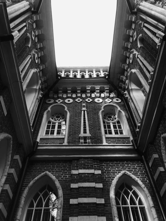 From below of black and white exterior of aged historic building of church with arched windows and ornamental details on walls