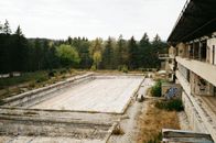 Forest around abandoned building with swimming pool