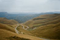 Narrow roads in mounts under foggy sky