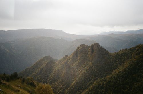 Free Spectacular view of mountains with green forests under sky with clouds in daylight Stock Photo