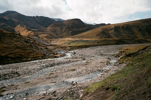 Free Creeks between high mountains under cloudy sky Stock Photo