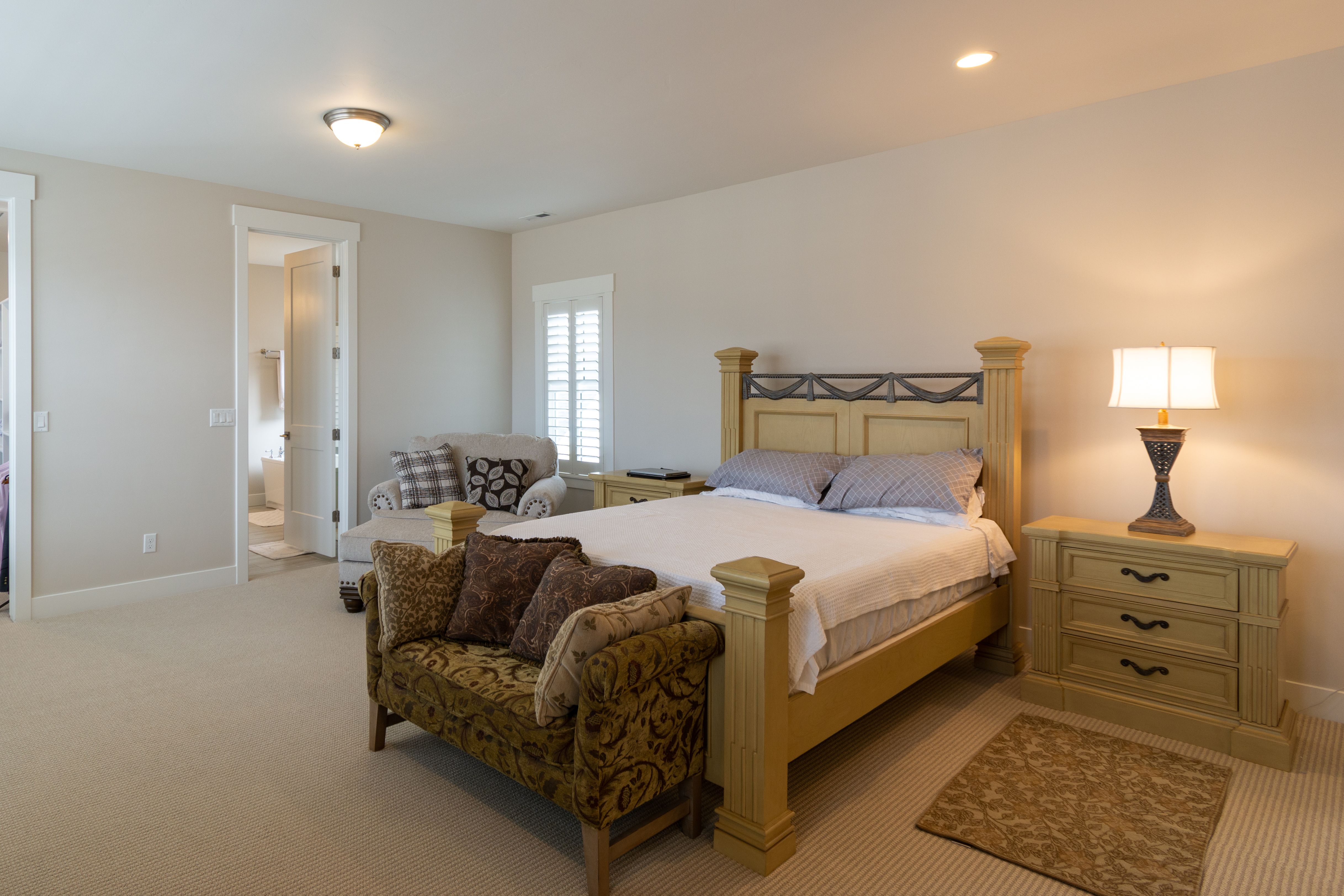 Coordinated bedroom suite with bed frame, bedside tables and dresser in a styled room