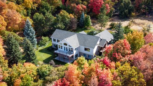 Free Charming suburban home surrounded by vibrant fall foliage in Woodland Hills, Utah. Stock Photo