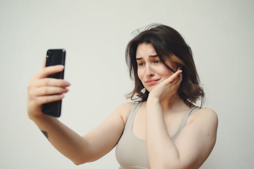 A Woman in Gray Tank Top Having a Selfie