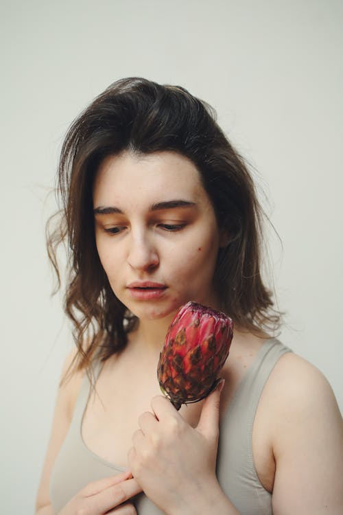 Free A Woman With Acne Holding a Flower Stock Photo