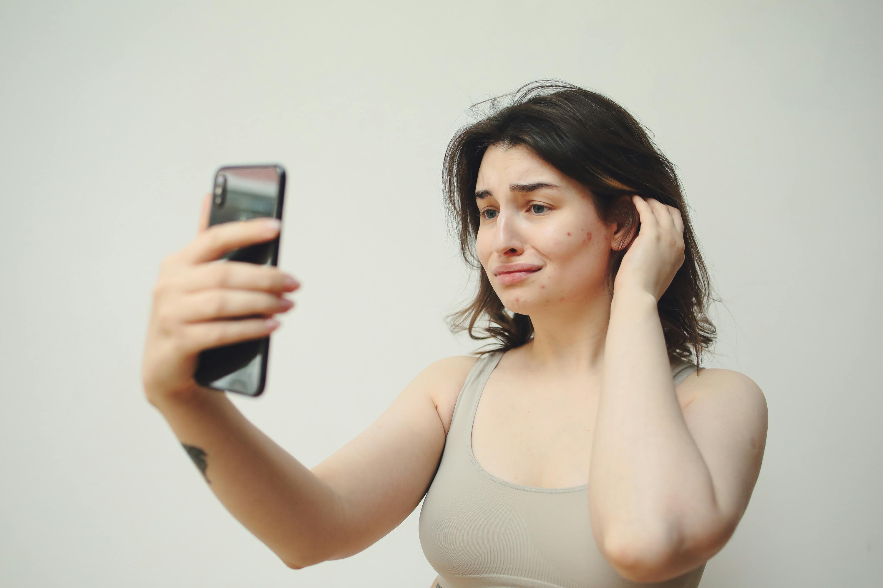 woman taking selfie wearing gray tank top by Ginger Girl. Photo stock -  StudioNow