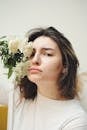 Woman in White Crew Neck Shirt With White Flower on Ear