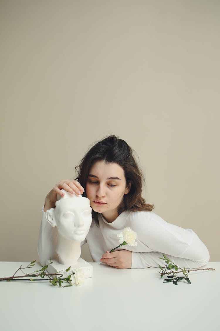 Beautiful Woman Holding A Face Sculpture