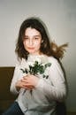 Woman in White Long Sleeve Shirt Holding White Flowers