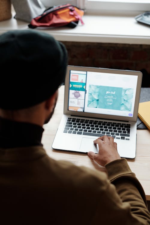 Man in Brown Sweater Using a Laptop