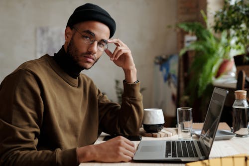 Man In Bruine Trui Met Macbook Pro