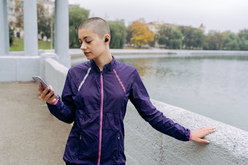 Woman in Purple Jacket Holding a Cellphone