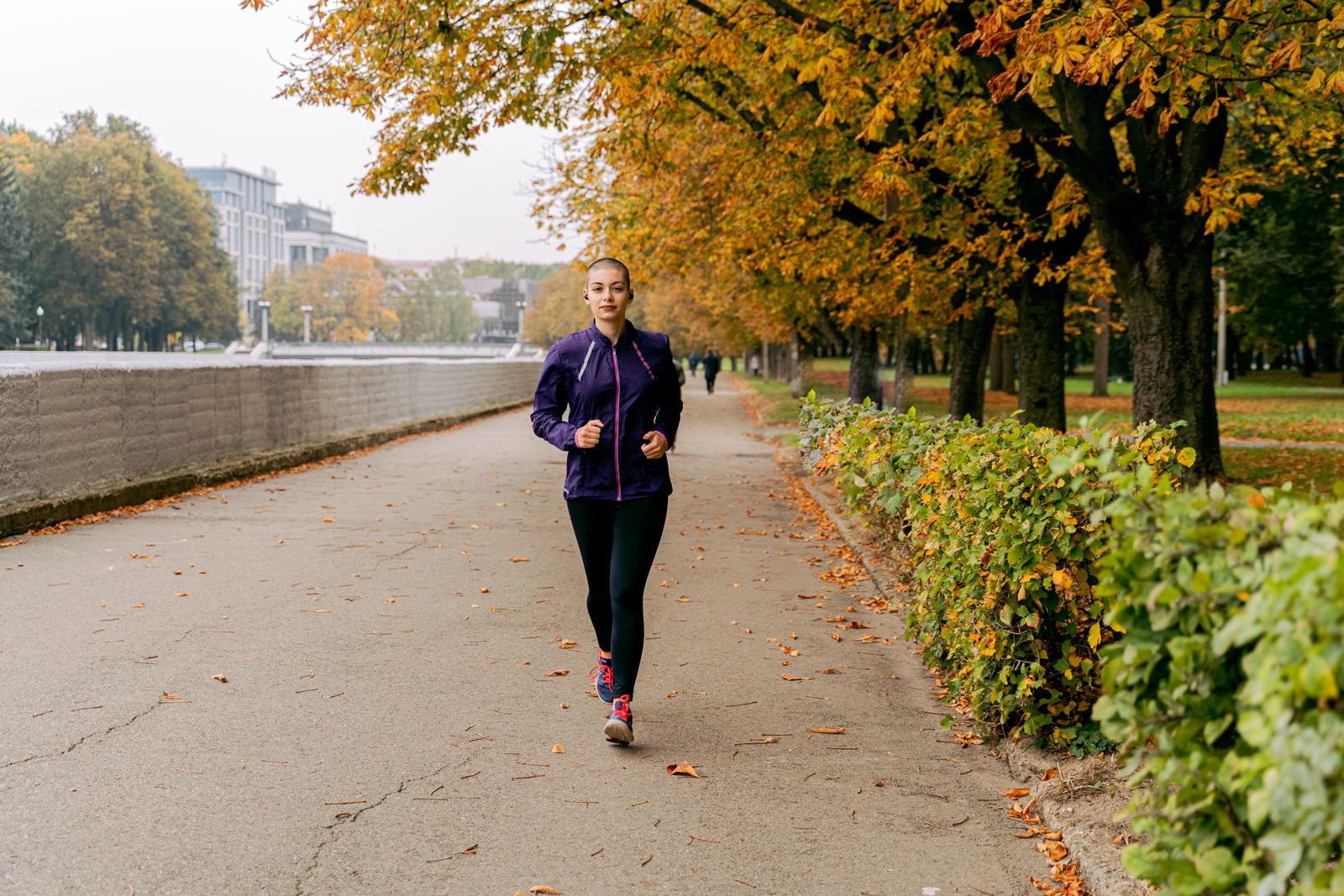 Runner stretching calf outdoors in bright daylight before using knee-high compression socks