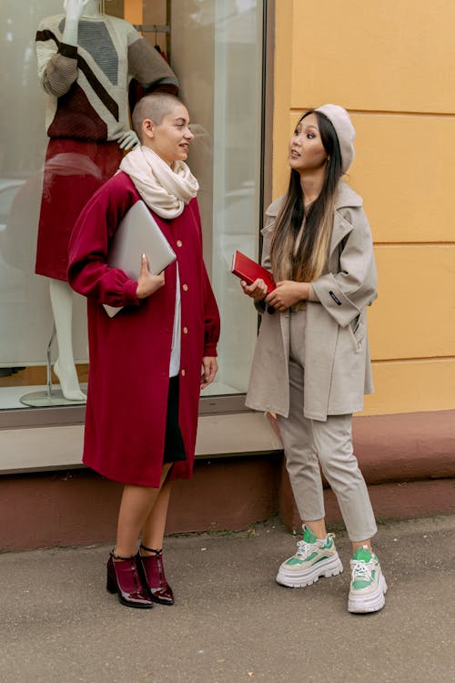 Women wearing Coats Standing Near a Store