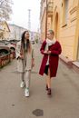 Woman in Red Skirt Standing Beside Woman in White Coat