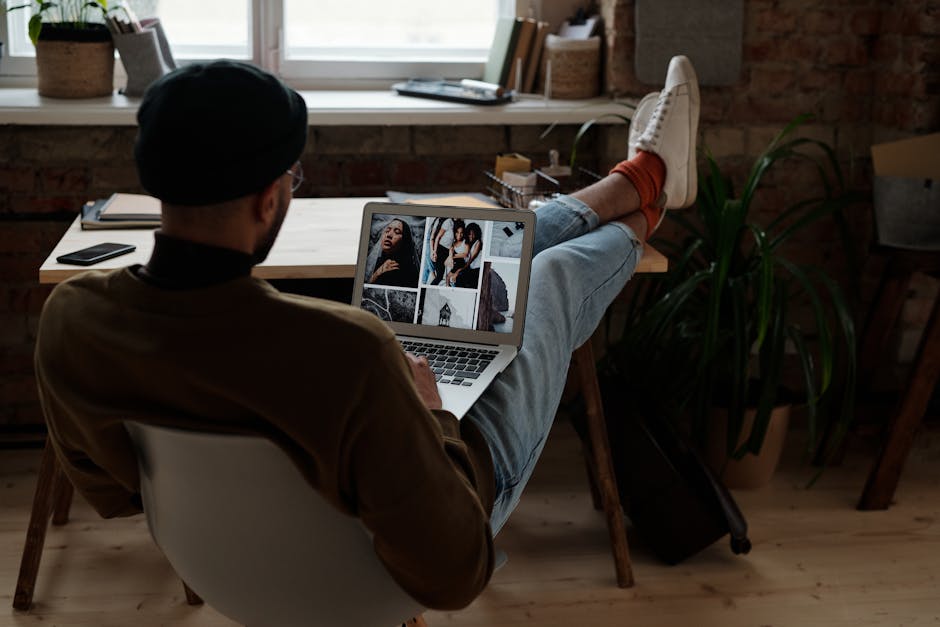 Does Monarch Actually Replace Mint in 2026? A male freelance designer in a beanie works from home, using a laptop at a stylish indoor workspace.