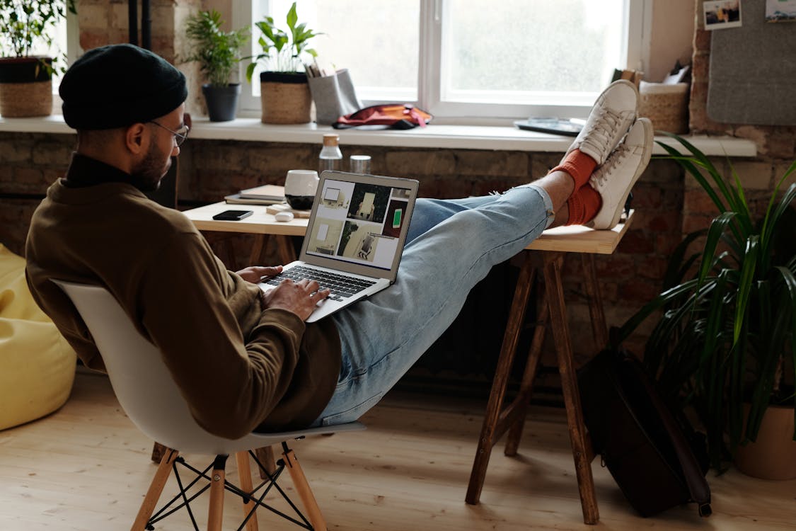 Free Man in Brown Sweater Working from Home Stock Photo