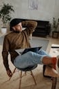 Man in Brown Sweater Sitting on Chair