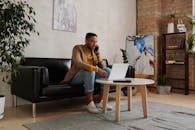 Man in Brown Crew Neck T-shirt Sitting on Black Couch